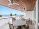 Inviting balcony features a dining table, lounge chairs and panoramic views of the beach and ocean at 1035 Seaside Dr # 305, Sarasota, FL 34242