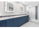 Modern bathroom features double sinks, decorative tile, illuminated mirrors, and a glass-enclosed shower with patterned accents at 1035 Seaside Dr # 305, Sarasota, FL 34242