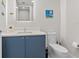 Clean bathroom boasts a blue vanity, white countertop, and a toilet with modern fixtures at 1035 Seaside Dr # 305, Sarasota, FL 34242