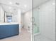 Bright bathroom features a glass shower and a blue vanity with modern fixtures at 1035 Seaside Dr # 305, Sarasota, FL 34242