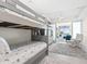 Bright bedroom features a gray bunk bed and an adjacent sitting area with ocean views at 1035 Seaside Dr # 305, Sarasota, FL 34242