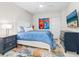 Cozy bedroom features a bed with blue comforter, colorful rug, and stylish decor at 1035 Seaside Dr # 305, Sarasota, FL 34242