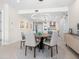 Elegant dining room featuring a modern circular light fixture above a wood table with seating for six, adjacent to an open kitchen at 1035 Seaside Dr # 305, Sarasota, FL 34242
