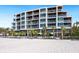 Elegant beachfront condo building with balconies and palm trees overlooking the ocean at 1035 Seaside Dr # 305, Sarasota, FL 34242