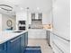 Stylish kitchen showcases white cabinetry, stainless steel appliances, a center island with blue accents, and a stone backsplash at 1035 Seaside Dr # 305, Sarasota, FL 34242