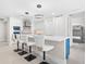 Well-lit modern kitchen with white cabinets, a center island with bar seating, and open access to the dining area and additional room at 1035 Seaside Dr # 305, Sarasota, FL 34242
