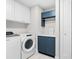 Well-organized laundry room with a washer, dryer, white cabinets, and blue accent cabinet at 1035 Seaside Dr # 305, Sarasota, FL 34242