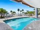 Relaxing pool deck with lounge chairs, palm trees, and a glimpse of the ocean at 1035 Seaside Dr # 305, Sarasota, FL 34242