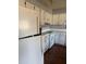 White kitchen cabinets, appliances, and laminate flooring at 406 Laurel E Rd, Nokomis, FL 34275