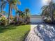 Well-maintained house featuring a lush lawn, palm trees, and a brick driveway at 4854 Sabal Lake Cir, Sarasota, FL 34238