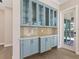 Built-in light blue cabinets with glass doors and quartz countertop at 616 Mangrove Point Rd, Siesta Key, FL 34242