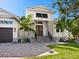 Front entry of a two-story home with stone accents and palm trees at 616 Mangrove Point Rd, Siesta Key, FL 34242
