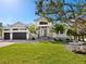 Two-story home with a three-car garage, stone accents and lush landscaping at 616 Mangrove Point Rd, Siesta Key, FL 34242