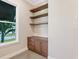 Home office with built-in shelves and cabinetry, hardwood floors and a window with a view at 616 Mangrove Point Rd, Siesta Key, FL 34242