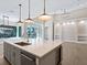 Kitchen island with sink, quartz countertop, and wine cooler at 616 Mangrove Point Rd, Siesta Key, FL 34242
