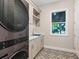 Laundry room with modern washer and dryer, white cabinets and patterned floor at 616 Mangrove Point Rd, Siesta Key, FL 34242