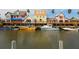 Waterfront view with boats docked along colorful buildings at 616 Mangrove Point Rd, Siesta Key, FL 34242