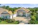 Stunning single-story home with a tile roof, teal accents, and lush landscaping at 7168 Ryedale Ct, Sarasota, FL 34241
