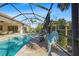 Screened-in pool area with patio furniture and landscaping at 7168 Ryedale Ct, Sarasota, FL 34241