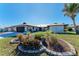 Landscaped front yard with circular garden bed and a two-car garage at 9363 Steubenville Ave, Englewood, FL 34224