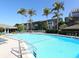 Community pool with lounge chairs and palm trees at 1080 W Peppertree Ln # 506A, Sarasota, FL 34242