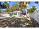 Cute bungalow, white exterior, blue accents, and a fenced yard at 2369 Browning St, Sarasota, FL 34237