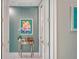 Stylish hallway featuring a decorative table, flamingo art, and textured blue accent wall at 505 Tamiami N Trl # 201, Venice, FL 34285
