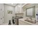 A tidy laundry room with a stainless steel washer and dryer, cabinets, sink, and charming whale artwork at 505 Tamiami N Trl # 201, Venice, FL 34285