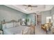 Comfortable bedroom with a tray ceiling, a decorative bed frame, and a peek into the en-suite bathroom at 505 Tamiami N Trl # 201, Venice, FL 34285