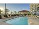 A refreshing community pool, framed by palm trees and lounge chairs, offers a relaxing resort-style experience at 505 Tamiami N Trl # 201, Venice, FL 34285