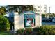 A sign for Dockside Waterfront Grill in Venice, Florida, with a vibrant fish logo and lush landscaping at 505 Tamiami N Trl # 201, Venice, FL 34285