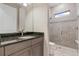 Well-lit bathroom featuring granite counters, decorative tile detail, and a glass-enclosed shower at 5050 Surfside Cir, Lakewood Ranch, FL 34211