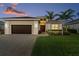 Inviting single-story home boasts lush landscaping, a paver driveway, and a two-car garage at 5050 Surfside Cir, Lakewood Ranch, FL 34211