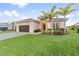 Inviting single-story home featuring a well-manicured lawn, landscaping, and a two-car garage at 5050 Surfside Cir, Lakewood Ranch, FL 34211