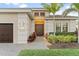 Charming front exterior featuring a double door entry, manicured lawn, and mature landscaping at 5050 Surfside Cir, Lakewood Ranch, FL 34211