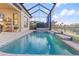 Private screened pool with lake views and tranquil waterfalls, enhanced by the privacy of the enclosure at 5050 Surfside Cir, Lakewood Ranch, FL 34211