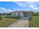Cute Florida home with a driveway and tropical landscaping at 740 Floral Ln, Port Charlotte, FL 33952