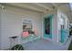 Inviting front porch with teal door, and coral chairs at 740 Floral Ln, Port Charlotte, FL 33952