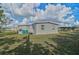 Back of house with large yard and green bins at 740 Floral Ln, Port Charlotte, FL 33952