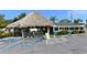 Restaurant exterior with tiki hut seating and blue handicap parking spaces at 8625 Midnight Pass Rd # 505B, Sarasota, FL 34242