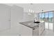 Bright condo kitchen featuring a large central island, sleek white cabinetry, and modern fixtures at 111 S Pineapple Ave # 1018, Sarasota, FL 34236