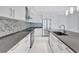 Condo kitchen with stainless steel appliances, sleek white cabinets, and grey quartz countertop at 111 S Pineapple Ave # 1018, Sarasota, FL 34236