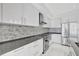 Contemporary condo kitchen with stainless steel appliances, mosaic backsplash, and sleek cabinetry at 111 S Pineapple Ave # 1018, Sarasota, FL 34236