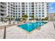 Bright pool and deck surrounded by lounge furniture with a multi-story condo building in the background at 111 S Pineapple Ave # 1018, Sarasota, FL 34236