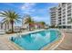 Stunning pool with palm trees and modern building architecture in the background under a sunny sky at 111 S Pineapple Ave # 1018, Sarasota, FL 34236