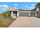 Two-story home with gray exterior, three car garage, and landscaped yard at 11160 Fieldstone Dr, Palmetto, FL 34221