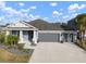 Two-story home with gray exterior, three car garage, and landscaped yard at 11160 Fieldstone Dr, Palmetto, FL 34221