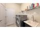 Laundry room with washer, dryer, utility sink, and shelving at 13789 Old Creek Ct, Parrish, FL 34219