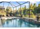 Inviting pool area with water feature, screened enclosure, and lounge chairs at 17424 Cresswind Ter, Bradenton, FL 34211