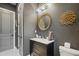 Chic powder room with black vanity, gold accents, and round mirror at 17424 Cresswind Ter, Bradenton, FL 34211